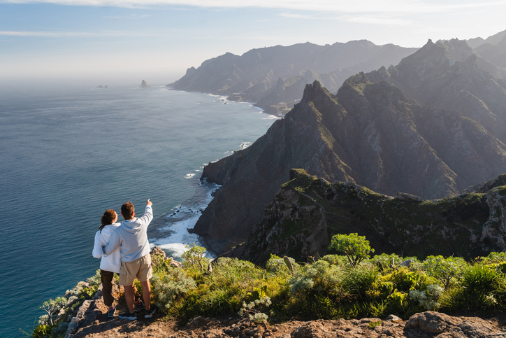 Couple enjoying vacation in nature. Hikers watching beautiful coastal scenery.